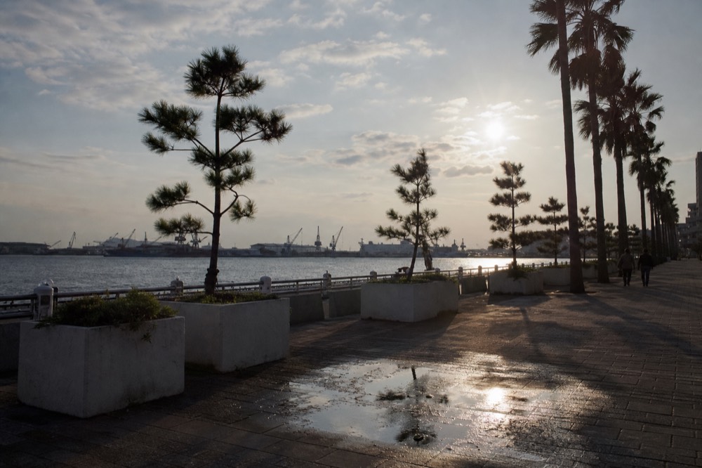 Waterfront promenade at Tempozan Harbour Village with open sky over Osaka Bay and distant harbour cranes
