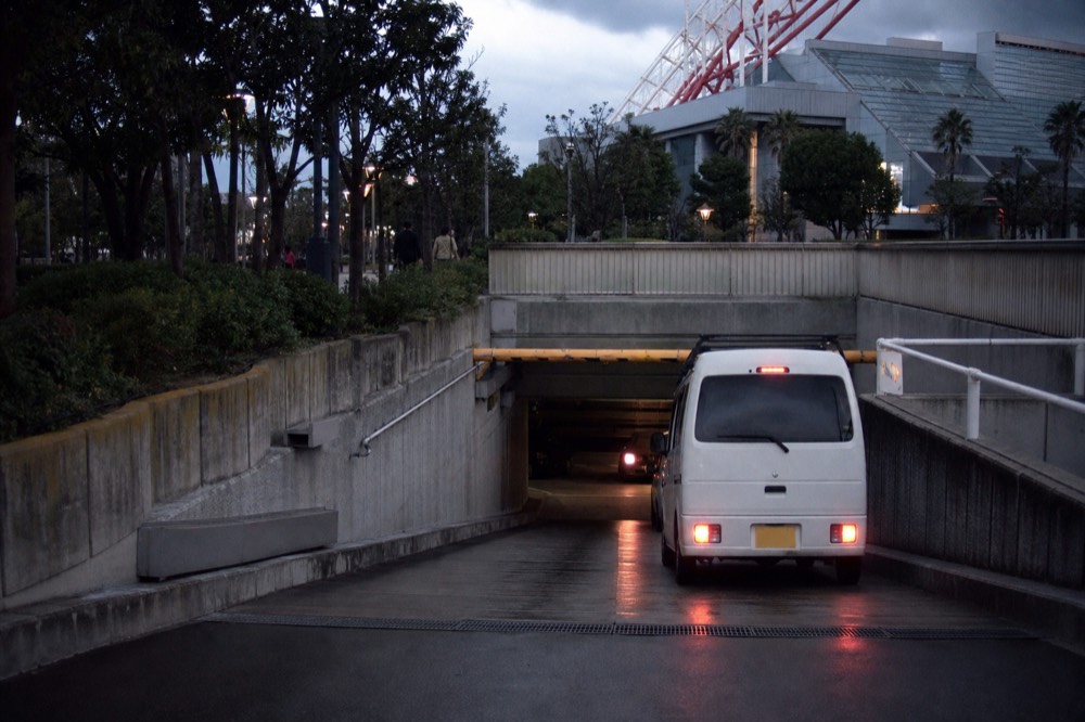 An underground car park entry with clearance bar and illuminated signage