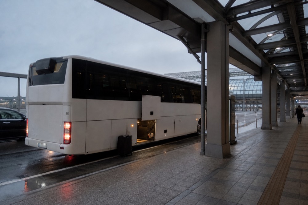 An airport limousine bus at a terminal kerbside with boarding passengers absent