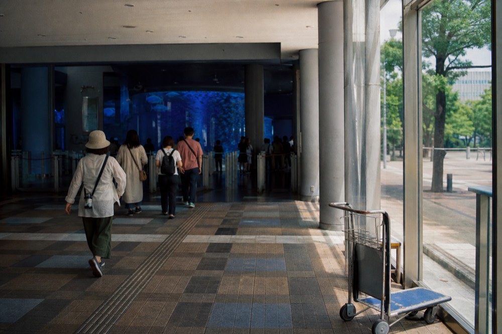 Visitors walking through the aquarium entrance hall toward the ticket gates