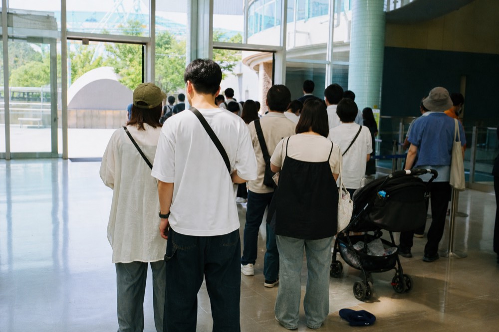 A queue of visitors waiting at the admission gates in the entrance building