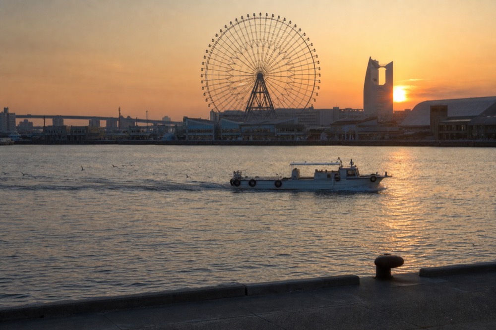 The Tempozan Ferris wheel and harbour buildings seen across the water at sunset