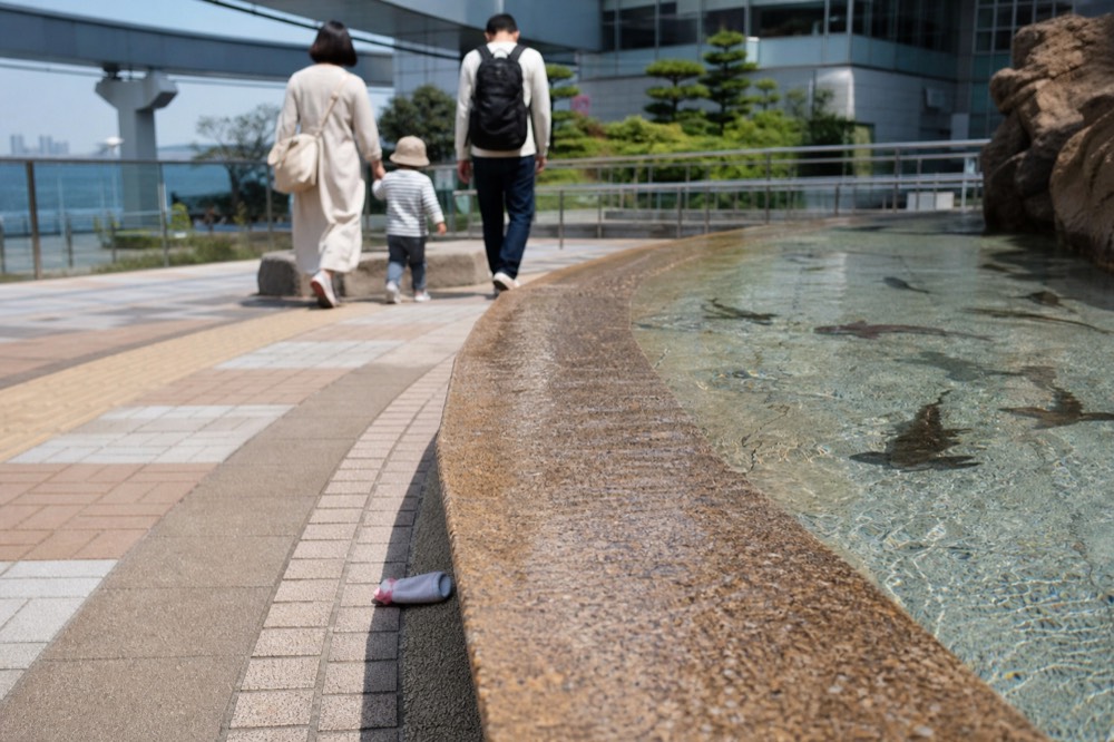 Family group walking beside a shallow touch pool with small sharks