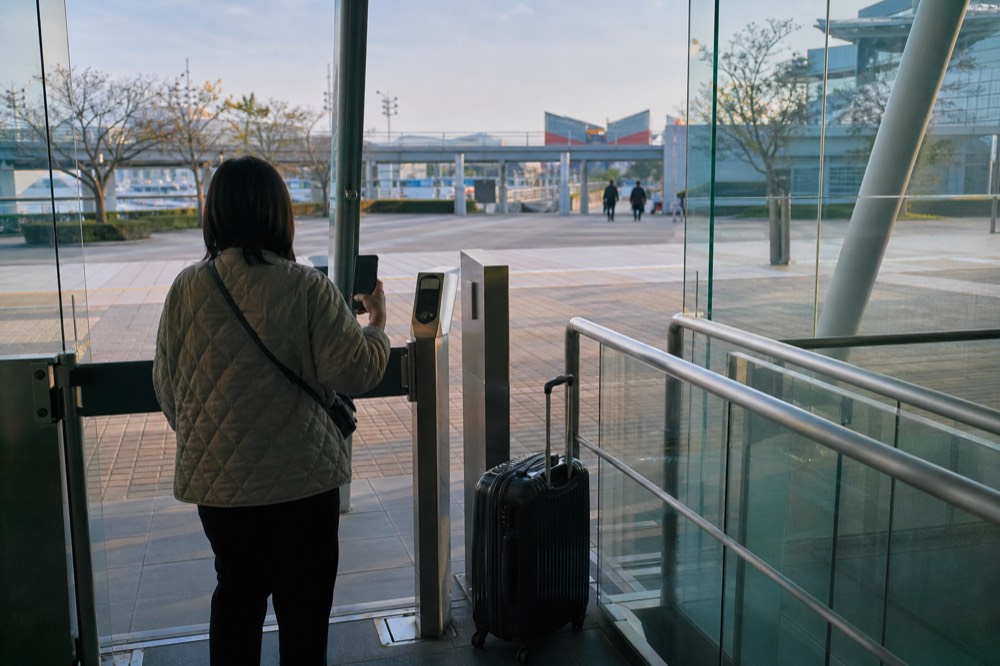Visitor scanning a phone QR code at an aquarium entry gate