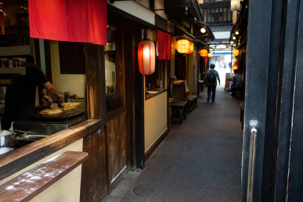 Lantern-lit stall fronts in a retro Japanese food alley