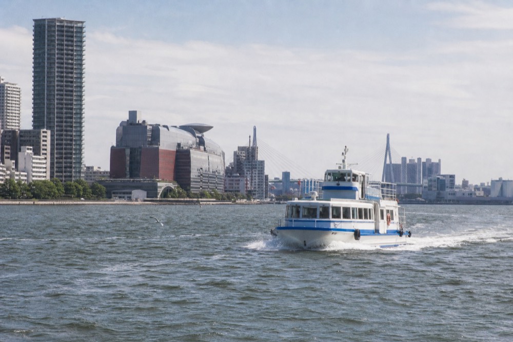 A small shuttle ferry crossing Osaka Bay toward Universal City Port