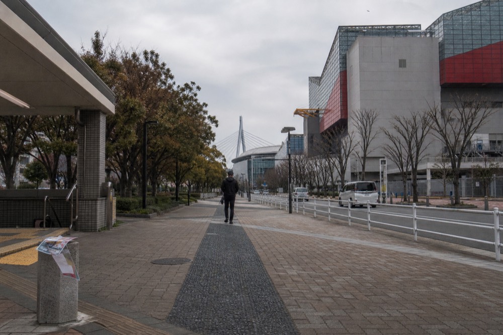 Harbor-side walkway between an aquarium building and a metro station entrance
